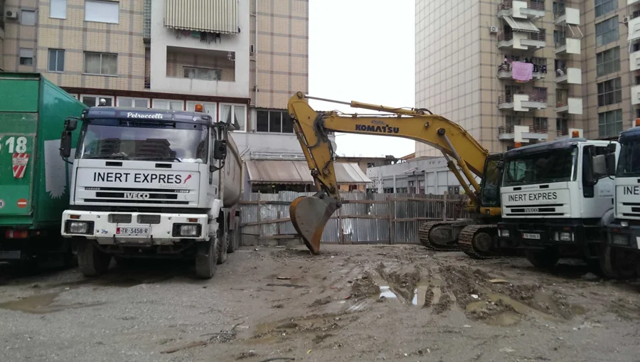 Kamionë dhe ekskavatorë të Inerte Express në një kantier urban