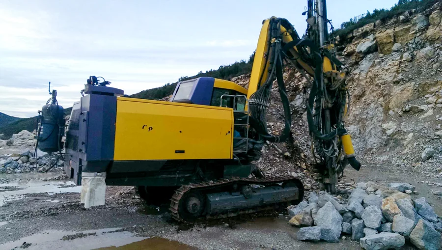 Makineri e verdhë pranë faqes shkëmbore të gurores