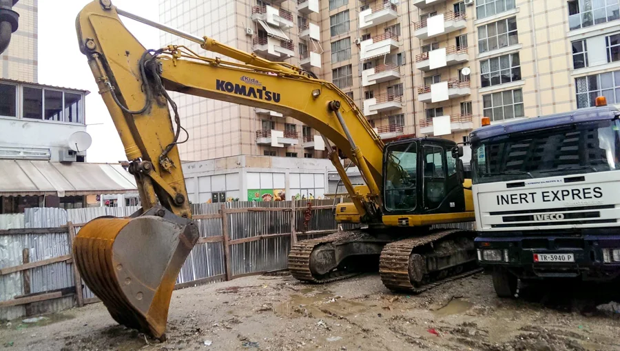 Ekskavator i verdhë dhe kamion i Inerte Express në kantier